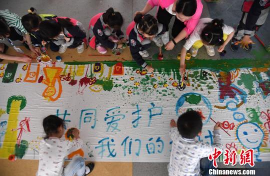 4月19日，江西省新余市蓓蕾幼兒園的小朋友在創(chuàng)作保護(hù)地球主題繪畫作品。　周亮　攝