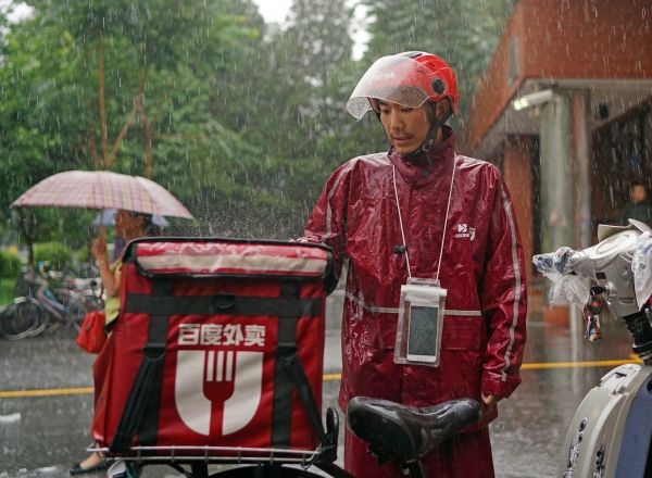 外賣送貨員在暴雨中堅持工作。新華社記者陳誠攝