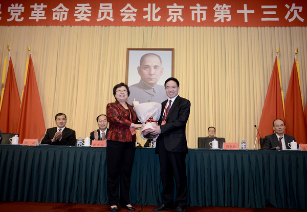 民革北京市第十五屆委員會主任委員王紅向民革北京市第十四屆委員會主任委員傅惠民鮮花。17