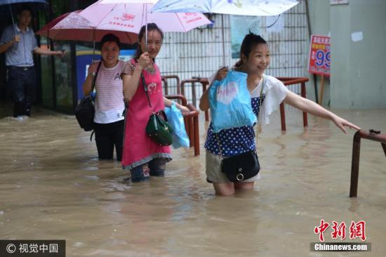 圖為南京市雨花臺(tái)區(qū)，市民在水中艱難出行。圖片來源：視覺中國