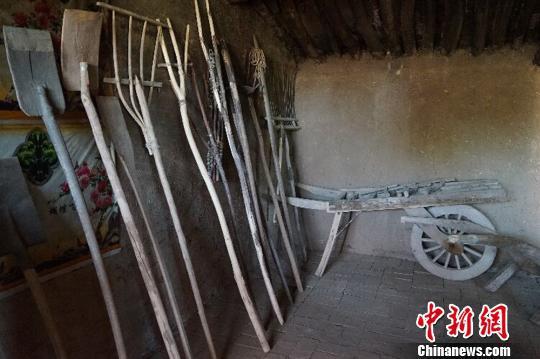 何世前的農(nóng)家小屋里，整齊地陳列著年代不種的農(nóng)具和生活用品。　陳思 攝