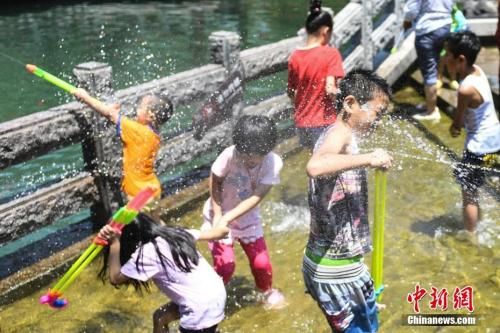 7月11日，幾名兒童在山東濟(jì)南“清泉石上流”池中戲水納涼。