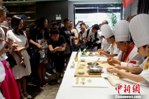 圖為烹飪大師現(xiàn)場廚藝表演，令華裔青年贊不絕口?！〈藜衙?攝