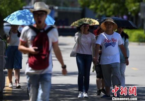 7月13日，廈門市民行走在熱浪滾滾的路面上?！埍?攝