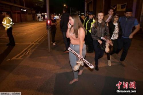 英國曼徹斯特體育館爆炸發(fā)生后，被疏散的歌迷們手里還拿著明星的海報。