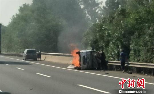 圖為：杭甬高速寧波段一輛面包車側(cè)翻后起火，好心人救一家7口。　何蔣勇 攝