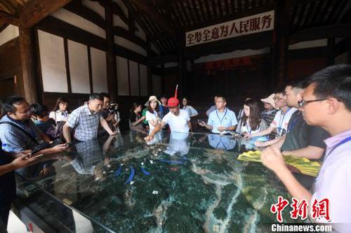 參加活動的記者在福建龍巖市長汀縣南山鎮(zhèn)的紅軍長征出發(fā)地——中復村采訪。　張斌 攝