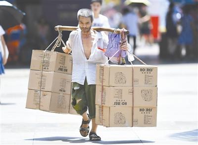 7月28日，一位搬運工在重慶市江北區(qū)觀音橋商圈頂著烈日搬運貨物。 當日，重慶市氣象臺發(fā)布高溫紅色預警信號，多個區(qū)縣的最高氣溫達40℃以上。 新華社記者 王全超 攝