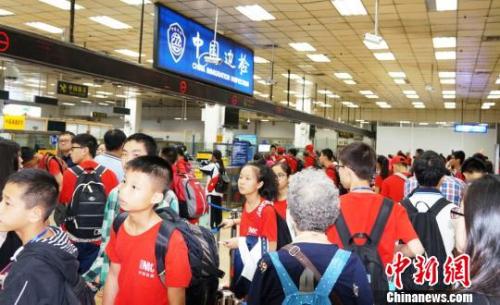 皇崗邊檢站增開通道快速為前往新加坡游學(xué)返程的三百余名廣西柳州的小學(xué)、中學(xué)生旅游團辦理入境手續(xù)?！↑S俊生 攝