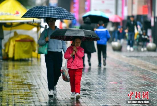 資料圖：9月24日，新疆烏魯木齊市降下秋雨，外出民眾打著雨傘快步前行。 <a target='_blank' href='http://www.chinanews.com/'>中新社</a>記者 劉新 攝
