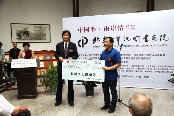 9月29日，在中國夢·兩岸情畫展開幕式上，民革株洲市委主委劉春正在接受北京正舉沈鵬書畫院院長沈鵬的義賣捐贈。
