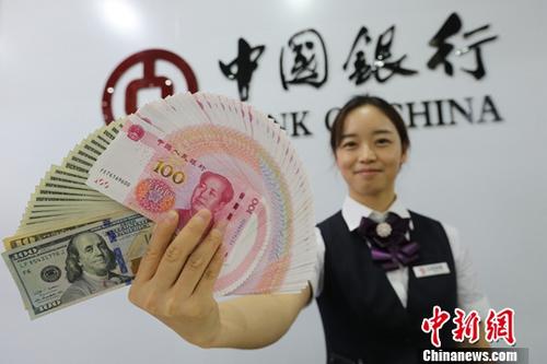 8月15日，山西太原，銀行工作人員展示人民幣、美元。<a target='_blank' href='http://www.chinanews.com/'>中新社</a>記者 張云 攝