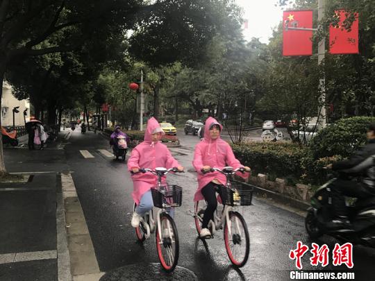 11日，南京迎來降溫降雨。圖為市民披上雨衣出行。　楊顏慈 攝