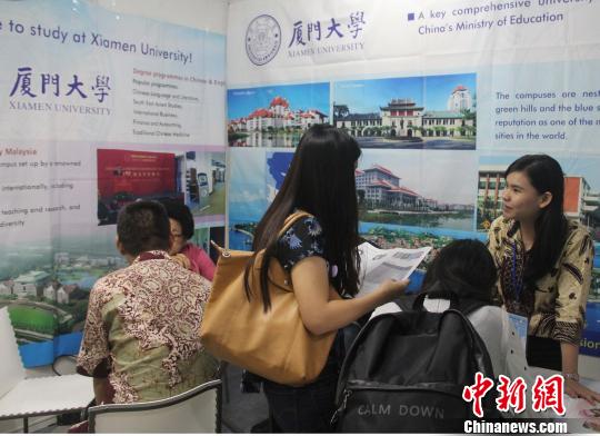圖為到廈門大學(xué)展位咨詢的印尼學(xué)生和家長(zhǎng)絡(luò)繹不絕?！×钟纻?攝