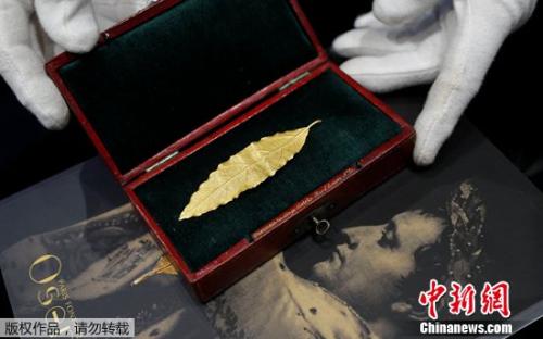 拍賣師展示一片黃金月桂葉，這片金葉子曾是拿破侖加冕禮皇冠上的幾十片金葉子之一。