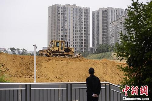 資料圖：市民觀望一樓盤(pán)工地上的推土機(jī)作業(yè)。<a target='_blank' href='http://www.chinanews.com/'>中新社</a>記者 楊華峰 攝