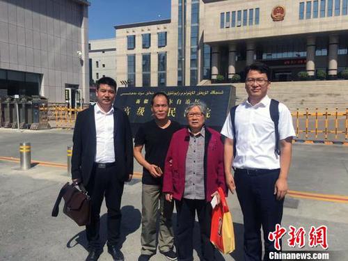 王興律師與李碧貞及周遠在新疆高級人民法院門前合影?！⊥跖d 攝