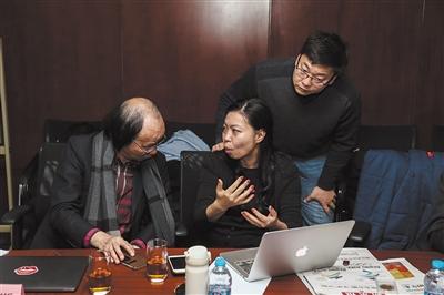 12月16日，2022年冬奧特許商品評(píng)審會(huì)現(xiàn)場(chǎng)，特許生產(chǎn)商與會(huì)徽設(shè)計(jì)者林存真(中)交流特許商品的改進(jìn)思路。圖片來源：新京報(bào)