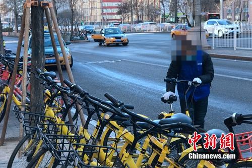 某街道辦事處工作人員看到倒地的共享單車主動(dòng)扶起來擺好。<a target='_blank' href='http://www.chinanews.com/' >中新網(wǎng)</a> 吳濤 攝