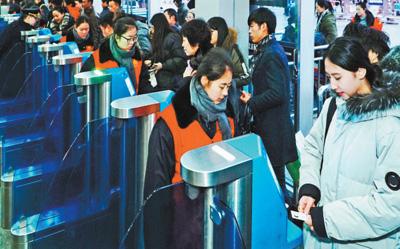 2月1日，旅客正在北京西站通過(guò)自助驗(yàn)票設(shè)備“刷臉”進(jìn)站。該站今年增加了18臺(tái)人臉識(shí)別設(shè)備，方便旅客快速進(jìn)站。本報(bào)記者 賀 勇攝