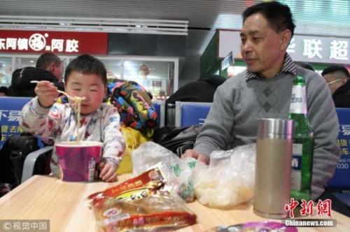 資料圖：春運途中，有旅客喝著小酒就花生。圖片來源：視覺中國