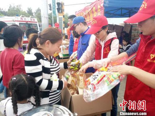 2月21日，?？谛潞８鄹浇?，志愿者為旅客發(fā)放食物?！∫Ｃ?攝
