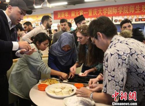 中國(guó)僑網(wǎng)圖為重慶大學(xué)留學(xué)生包餃子和湯圓共慶元宵節(jié)。　鐘欣　攝