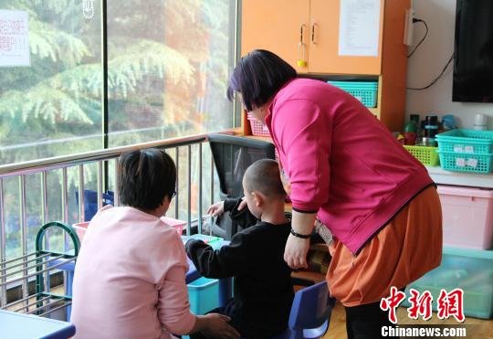 走進(jìn)濟(jì)南安安特殊兒童康復(fù)中心，老師和家長(zhǎng)正帶著自閉癥孩子玩游戲。　趙曉 攝
