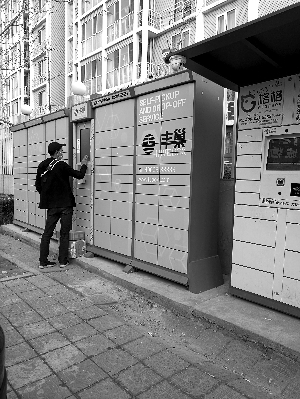 快遞員掃碼將快遞包裹逐一放入柜子中。圖片來(lái)源：北京晨報(bào)