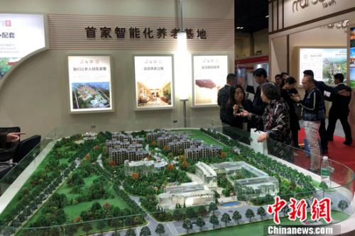 2018北京春季房展會上某養(yǎng)老地產(chǎn)項目的工作人員在向觀眾進(jìn)行介紹。程春雨 攝