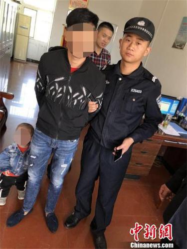 孝感市警方將嫌疑人帶走，并準備將其孩子送到家人身邊 鐘欣 攝