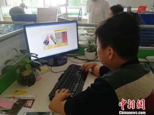 4月28日，在江西省寧都縣電商園103室，美編在設(shè)計(jì)圖片?！√K路程 攝