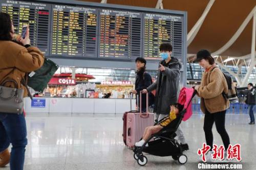 旅客帶著孩子前往辦票柜臺辦理登機手續(xù)。　殷立勤 攝