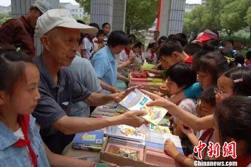 周火生和志愿者們通過書籍義賣籌集捐助款。周火生希望愛心接力可以不斷延續(xù)下去?！≠Y料圖片 攝