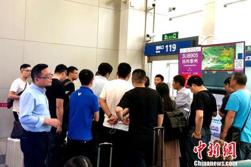 圖為大批乘客向成都雙流機(jī)場工作人員了解延誤原因?！↑S心玥 攝