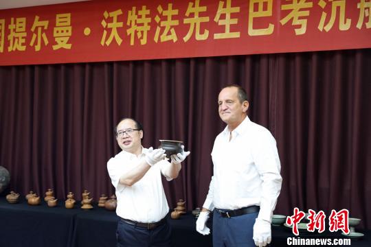  提爾曼-沃特法（右）向湖南省博物館捐贈(zèng)巴考沉船代表文物明景德鎮(zhèn)窯醬釉三足香爐。湖南省博物館供圖
