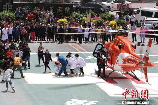5月23日，遼寧省人民醫(yī)院完成中國(guó)東北首例異地航空醫(yī)療轉(zhuǎn)運(yùn)任務(wù)。圖為急救人員立即將患者抬上急救床?！≈烀饔?攝