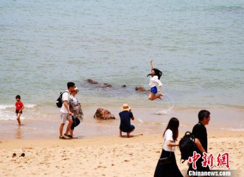 資料圖：端午假期，游客在三亞海邊嬉水?！⊥鯐员?攝