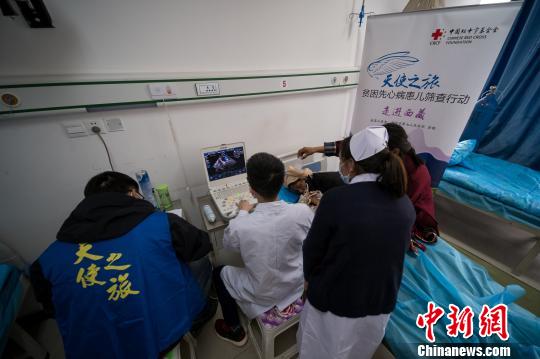 圖為醫(yī)療專家通過心臟彩超篩查先心病患兒。　何蓬磊 攝