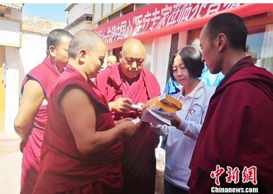 圖為專家為僧人叮囑服藥注意事項(xiàng)?！∧先缱楷?攝