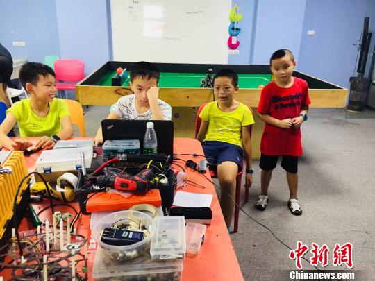 7月21日，在廣西柳州一家培訓機構，學生動手制作機器人?！≈転t男 攝