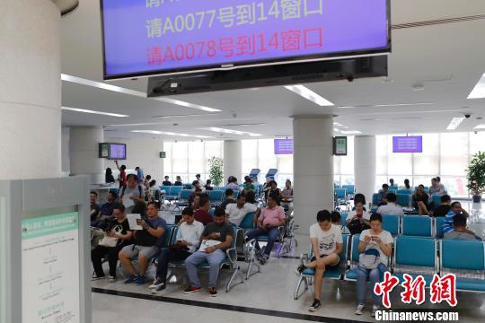 民眾正在上海市公安局出入境管理局內(nèi)，等待辦理相關(guān)業(yè)務(wù)。　殷立勤 攝