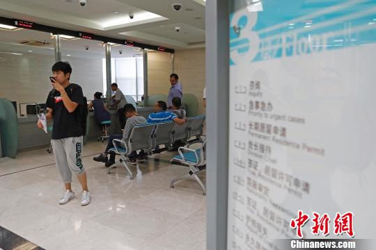 上海市公安局出入境管理局內(nèi)，民眾正在咨詢(xún)和辦理相關(guān)業(yè)務(wù)?！∫罅⑶?攝