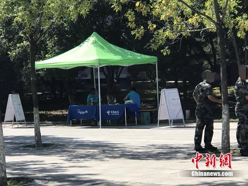 中國(guó)電信在某高校內(nèi)擺攤出售手機(jī)卡，旁邊就是正在軍訓(xùn)的學(xué)生。<a target='_blank' href='http://www.chinanews.com/' >中新網(wǎng)</a> 吳濤 攝