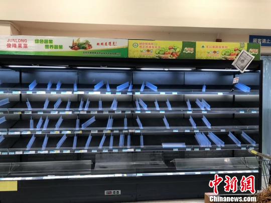 圖為16日，南寧一家沃爾瑪超市內(nèi)被購空的果蔬菜架?！＄娦?攝