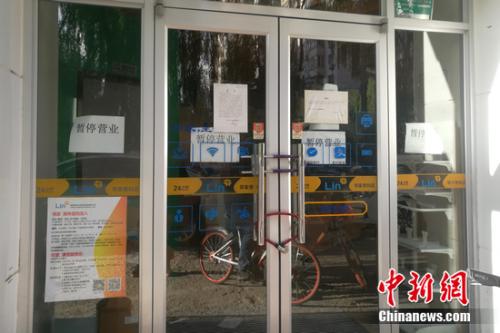北京街邊的某鄰家便利店大門緊鎖，并張貼著暫停營運的公告。