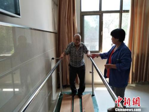 資料圖：老人在護(hù)工的協(xié)助下進(jìn)行康復(fù)訓(xùn)練。陳建華、薛艷偉供圖