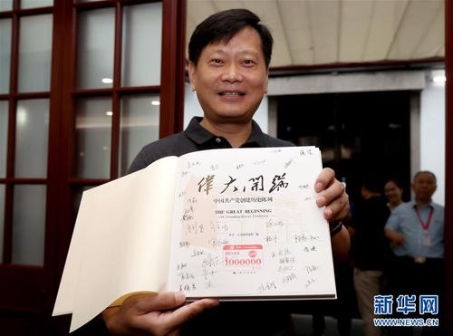 在中共一大會(huì)址紀(jì)念館內(nèi)，今年的第100萬名觀眾劉凱在展示獲贈(zèng)的精裝圖冊《偉大開端》（8月25日攝）。圖冊扉頁上蓋有“第1000000名觀眾”紀(jì)念章，還有紀(jì)念館全體工作人員的簽名。新華社記者 劉穎 攝