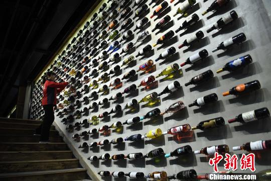 圖為工作人員正在展廳內(nèi)擦拭紅酒瓶。　陳超 攝