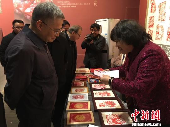 文化和旅游部黨組成員、副部長項兆倫參觀豐寧滿族剪紙展位?！「呒t超 攝
